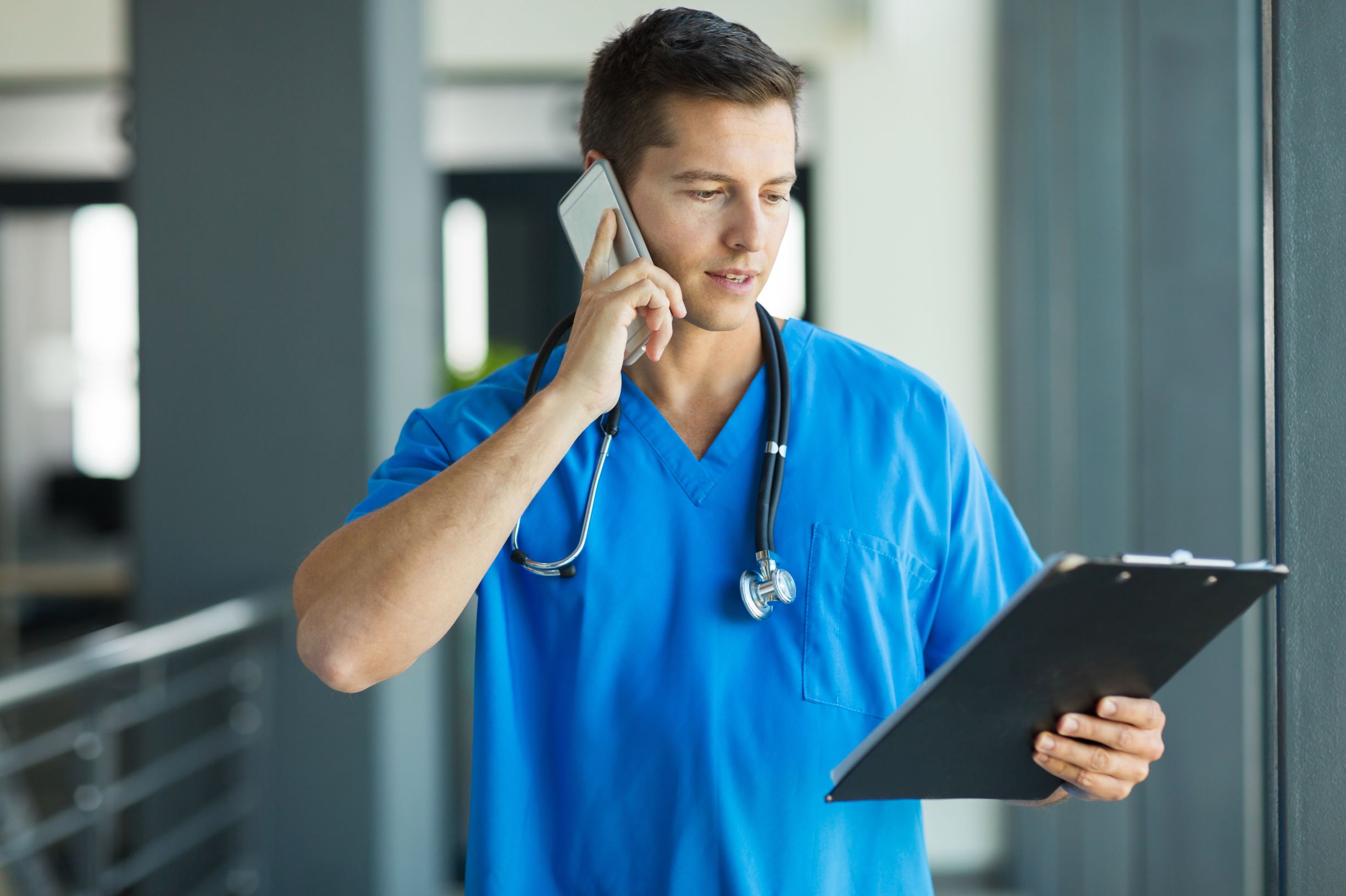 Doctor on phone holding tablet 